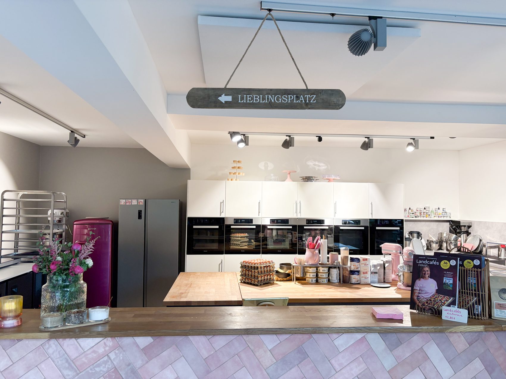 Der Tresen mit rosa Fischgrätmuster und dem Schild Lieblingsplatz im Café Backgeflüster
